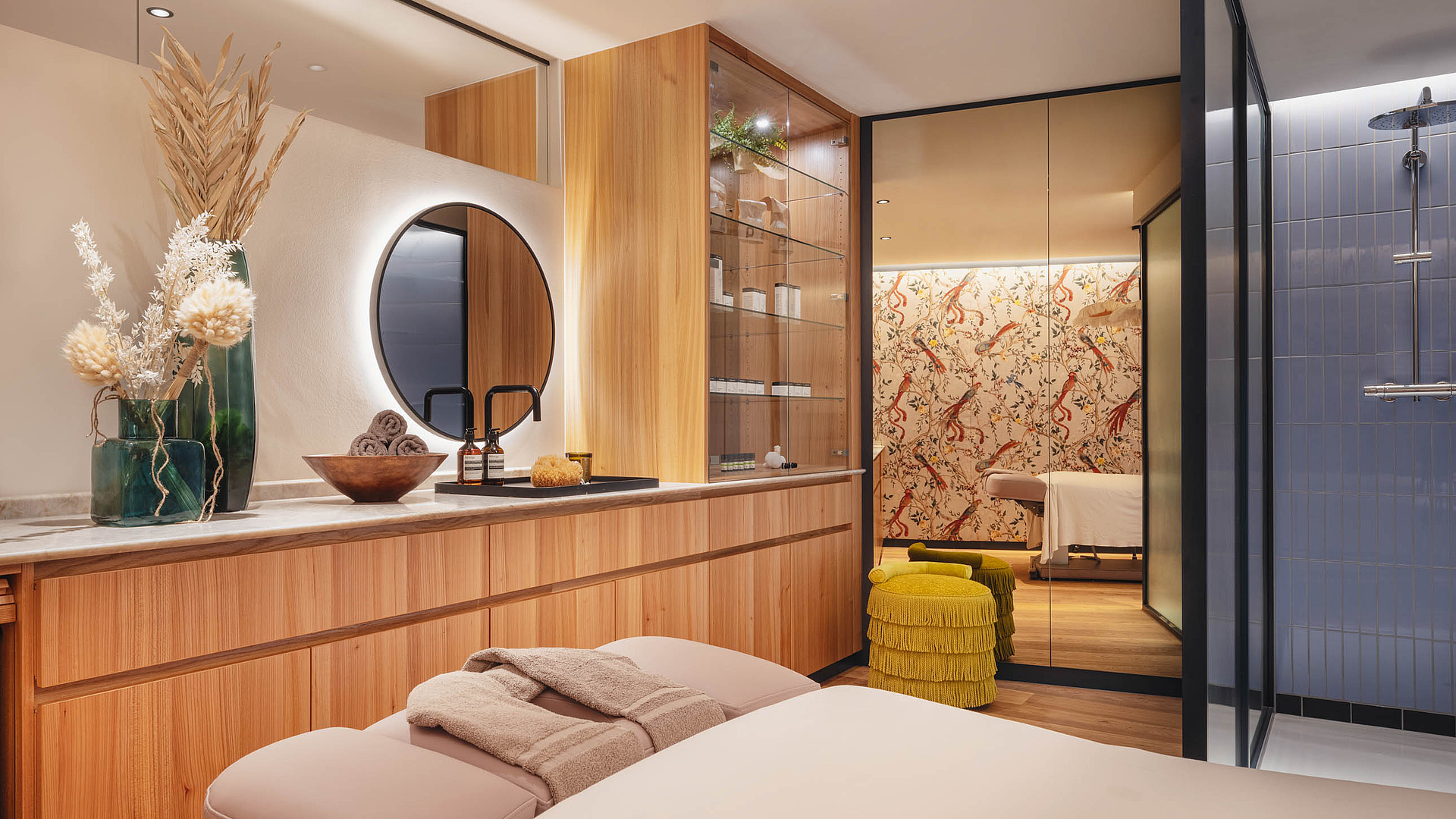 Innenansicht des Beauty- und Massagebereichs mit hellbraunen Holzmöbeln und Massageliege.