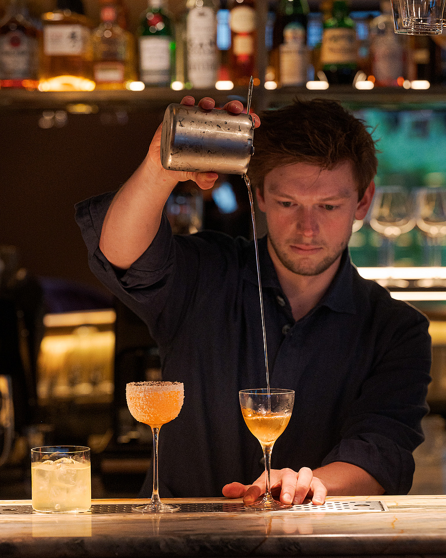 Barkeeper bei der Zubereitung eines Cocktails an der Bar