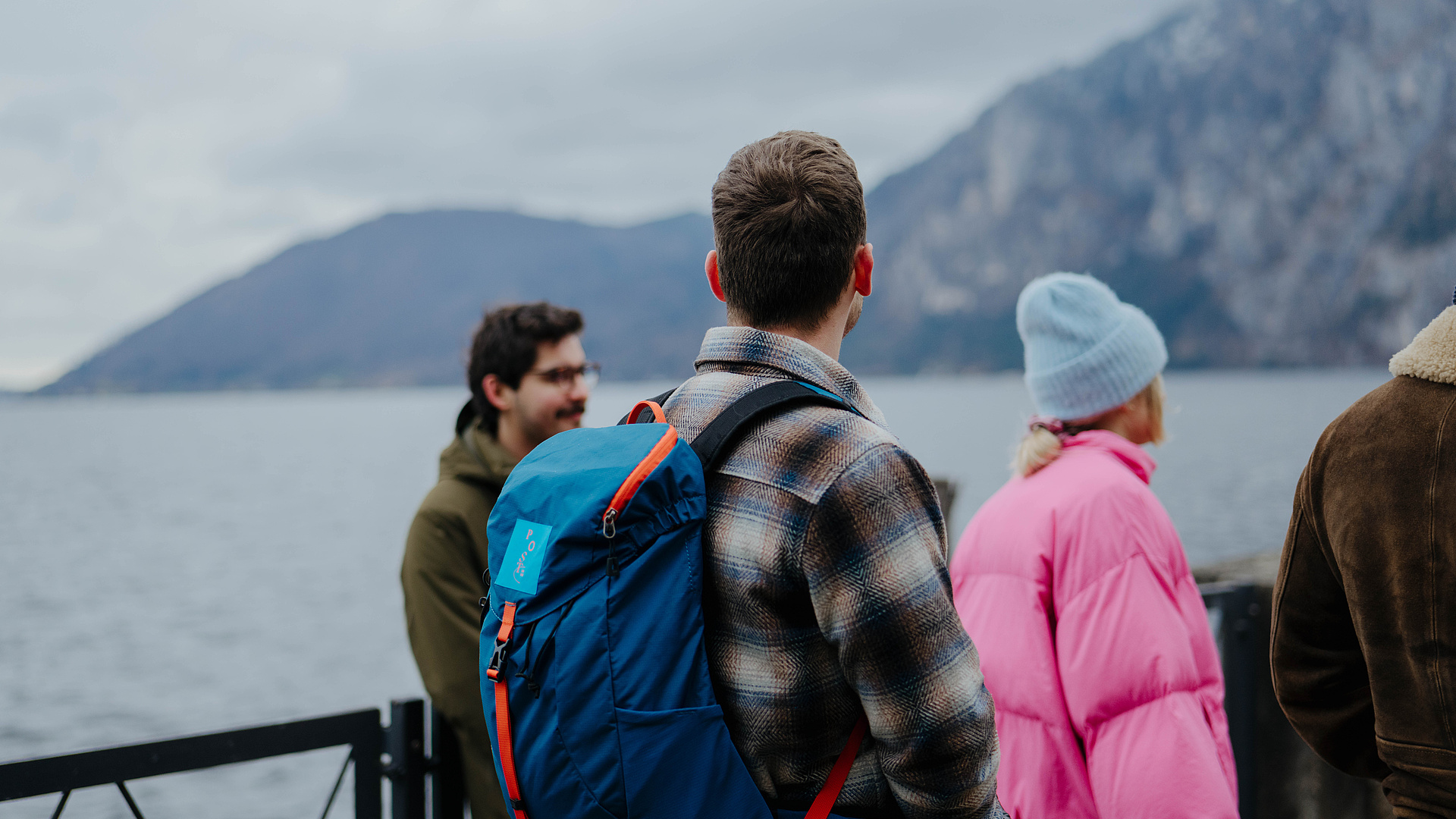 Gäste bei einem Ortsrundgang am Traunsee bei schlechtem Wetter, einer mit blauem Rucksack vom Hotel