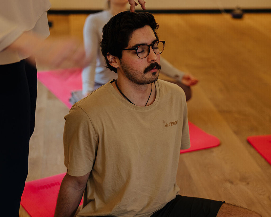 Gäste nehmen an einer Breathwork-Session mit der Coachin im Yogaraum teil