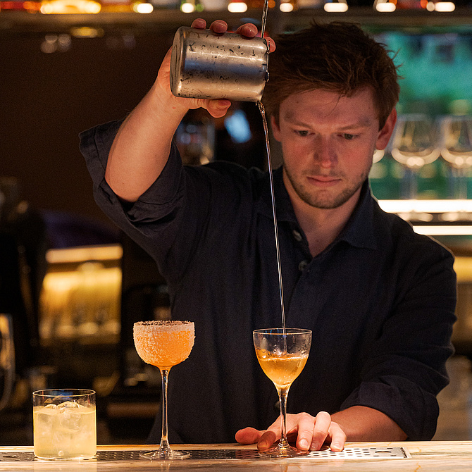 Barkeeper bei der Zubereitung eines Cocktails an der Bar