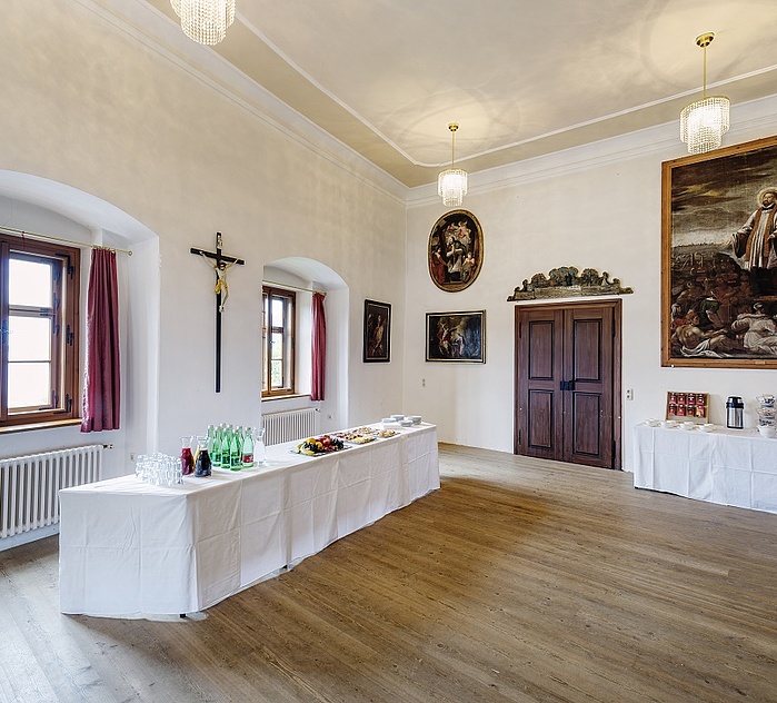 Historischer Veranstaltungsraum in Traunkirchen mit Buffet, Getränken, Holzboden und großformatigen Gemälden.