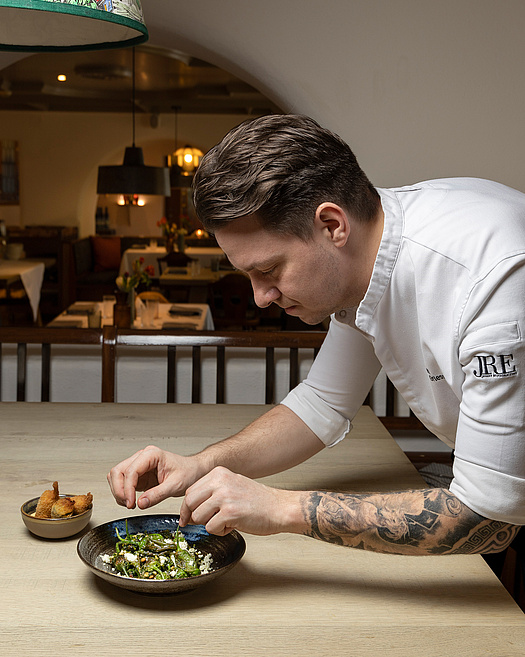 Küchenchef richtet Pimientos Padron am Restauranttisch an