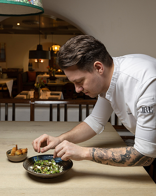 Küchenchef richtet Pimientos Padron am Restauranttisch an