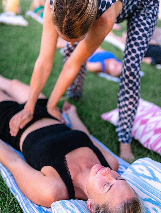 Gast entspannt auf der Wiese während einer Yoga-Session mit Coachin Hemma