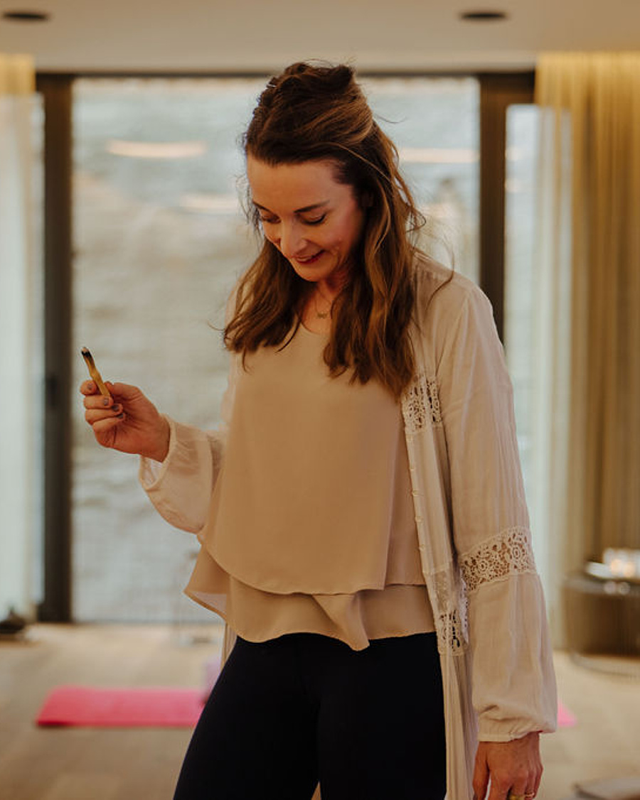 Meditationscoachin leitet eine Breathwork-Session mit Räucherstäbchen im Yogaraum des Hotels