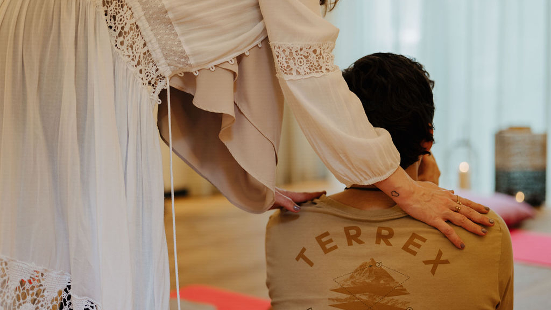 Breathwork-Session im Yogaraum mit Gast und Meditationscoachin im langen weißen Kleid