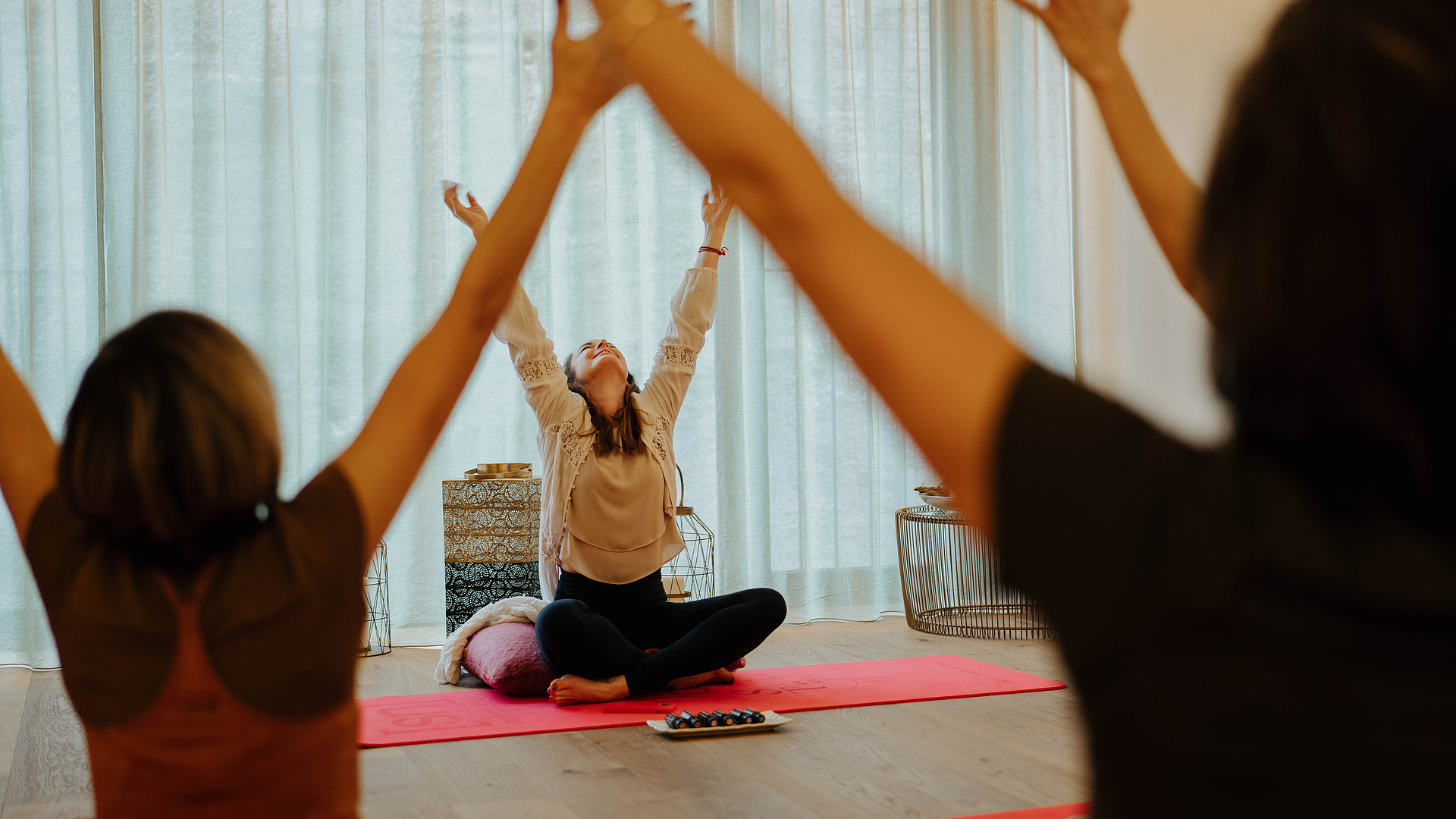 Gäste bei einer Breathwork-Session mit der Coachin vor einem offenen Fenster im Yogaraum