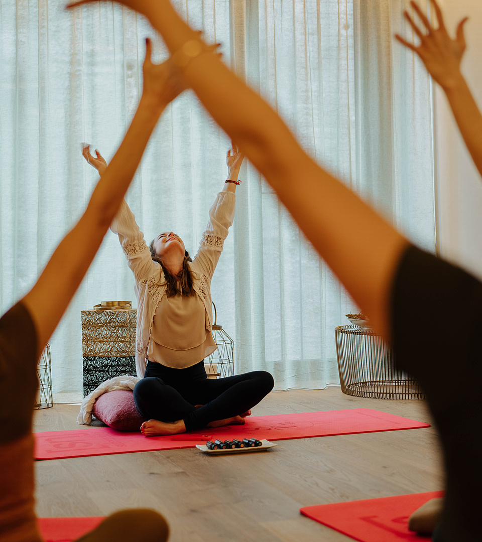 Gäste bei einer Breathwork-Session mit der Coachin vor einem offenen Fenster im Yogaraum