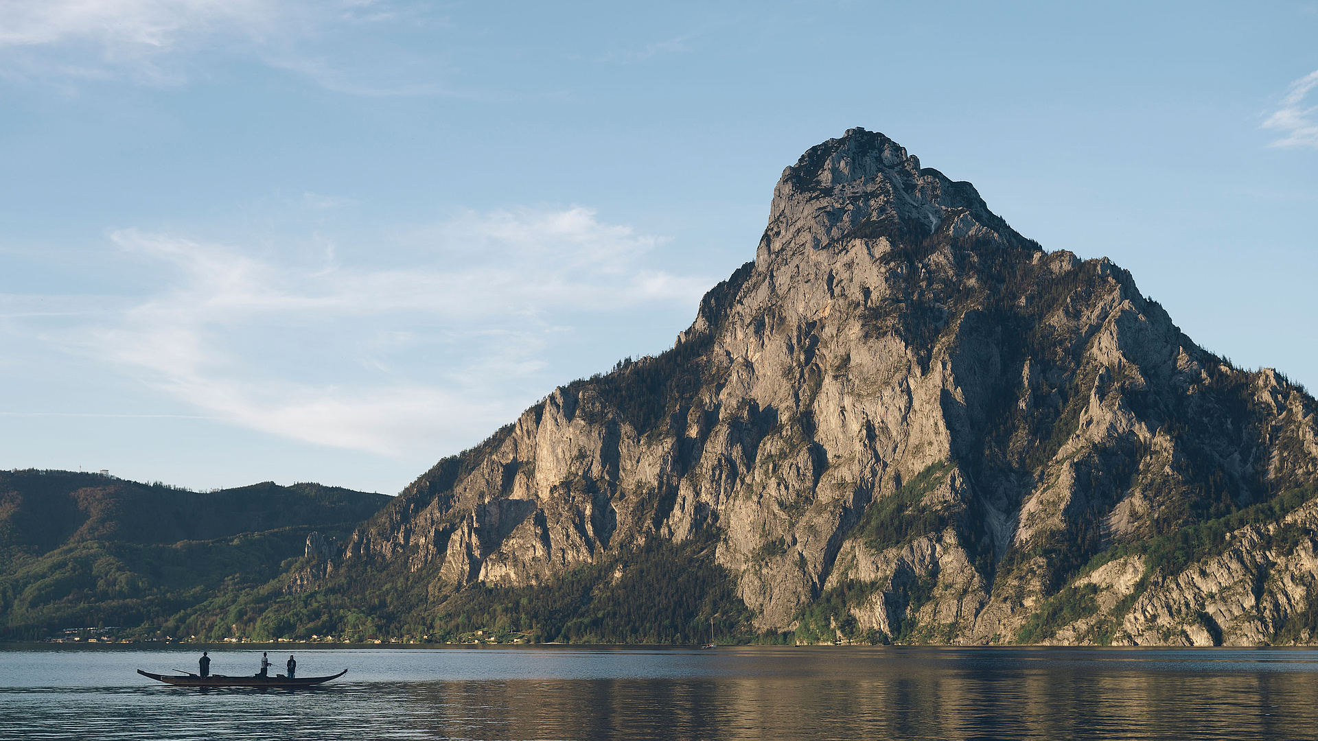 Plätte mit Fischern auf dem Traunsee, im Hintergrund der Traunstein und blauer Himmel.