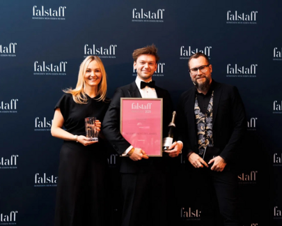 Chef de Bar Markus hält die Falstaff-Auszeichnung für die "Bar des Jahres 2025" in der Hand, mit der blauen Falstaff-Werbung im Hintergrund.