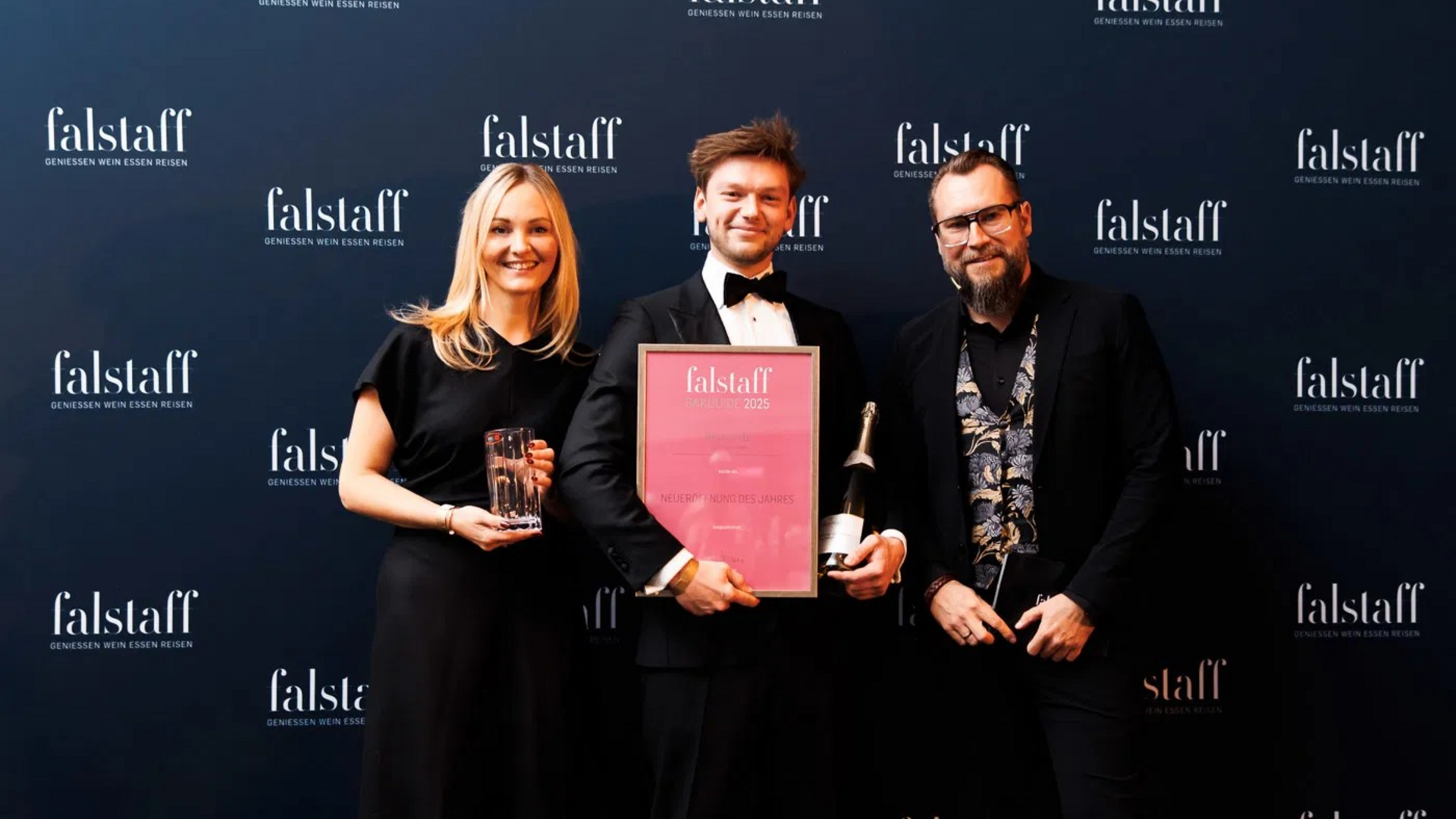 Chef de Bar Markus hält die Falstaff-Auszeichnung für die "Bar des Jahres 2025" in der Hand, mit der blauen Falstaff-Werbung im Hintergrund.