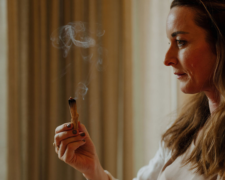 Meditationscoachin mit Räucherholz im Yogaraum des Hotels