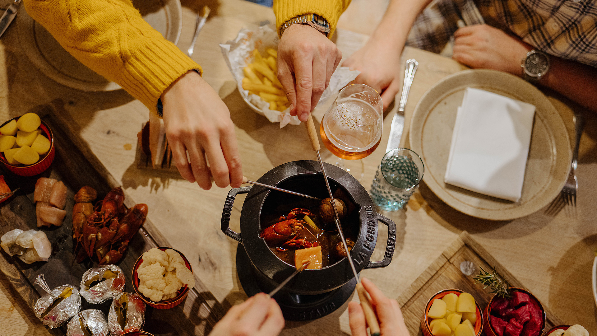Draufsicht auf vier Personen beim Fondue-Essen in der Poststube 1327