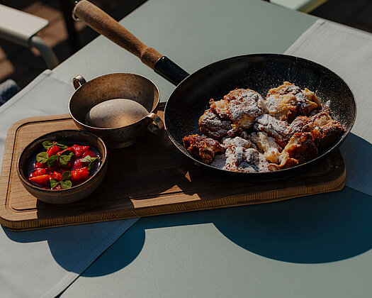Kaiserschmarrn mit Erdbeeren und Vanilleeis serviert im Gastgarten