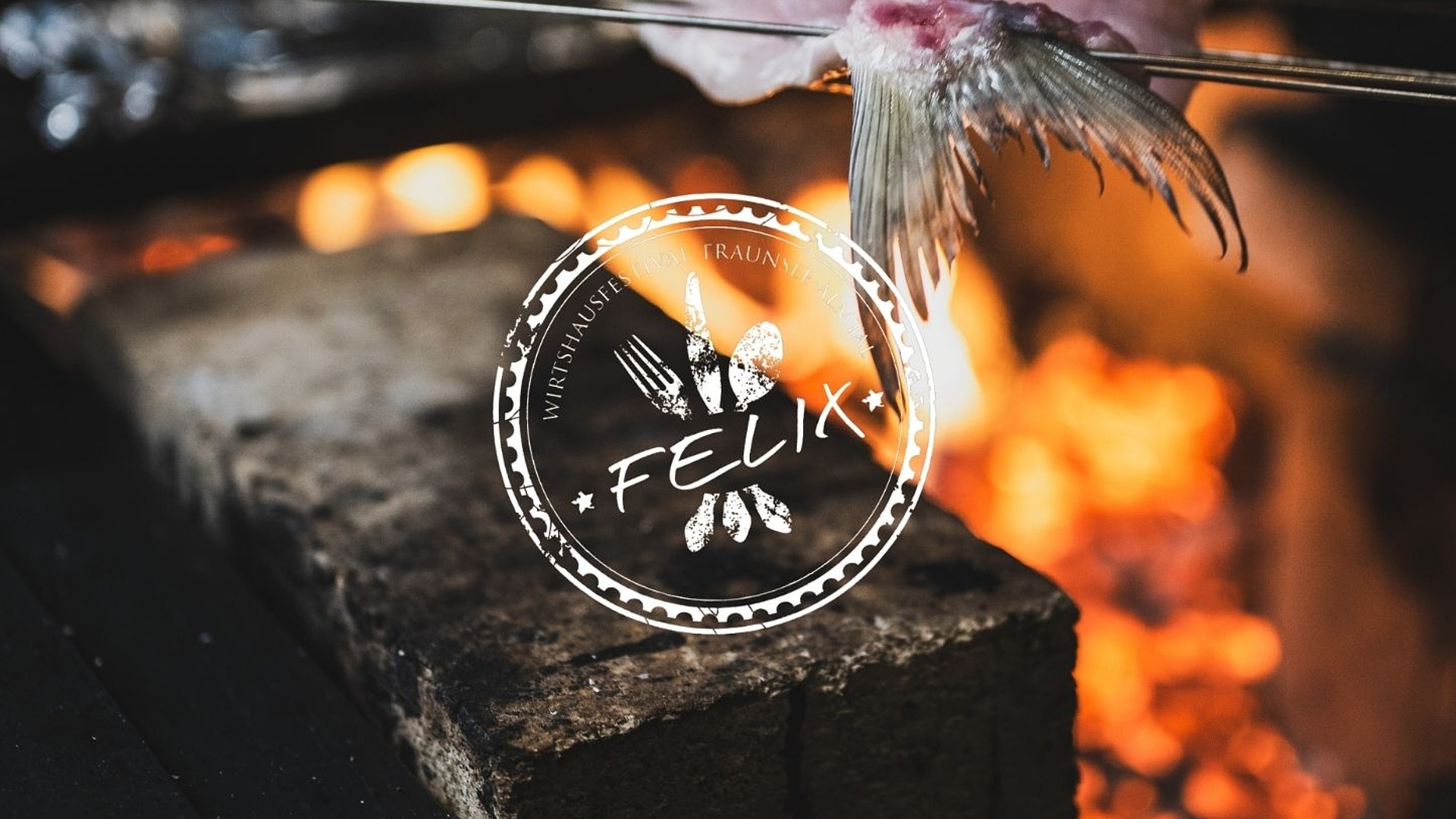 Fischfilet auf kleinen Metallspießen über glühender Holzkohle, verfeinert durch offenes Feuer. Logos von Gröller Hospitality und Felix.